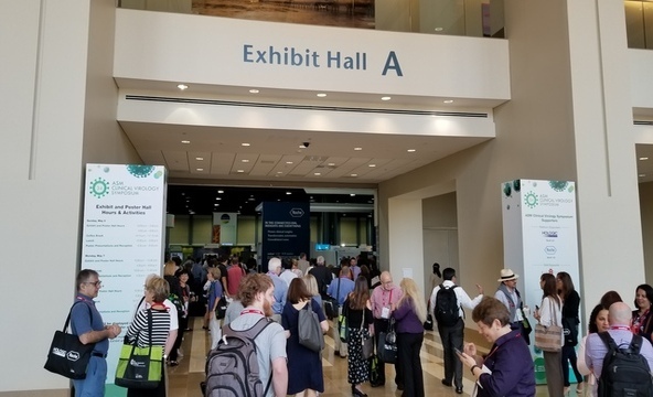 A large group of attendees stand at the entrance to Exhibit Hall A at ASM CVS.