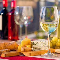 Examples of fermented products - wine, cheese - arranged on a table.