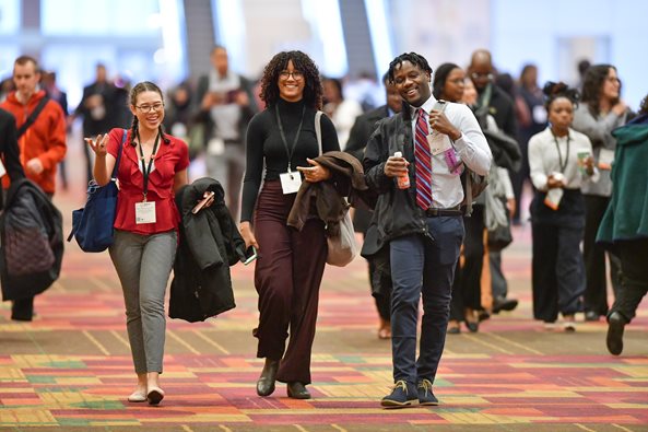 A photo graph taken at ASM Microbe focusing on three young professional scientists walking together and smiling.