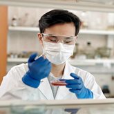 Lab technician working with Petri dish