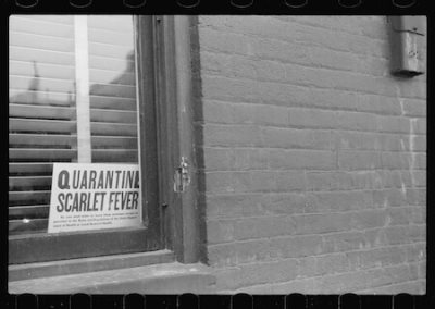 A scarlet fever quarantine sign is displayed in the window of the home of an infected patient in 1940.