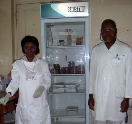 Laboratory staff pose in front of an incubator unit.