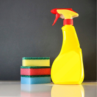 A spray bottle next to three sponges.