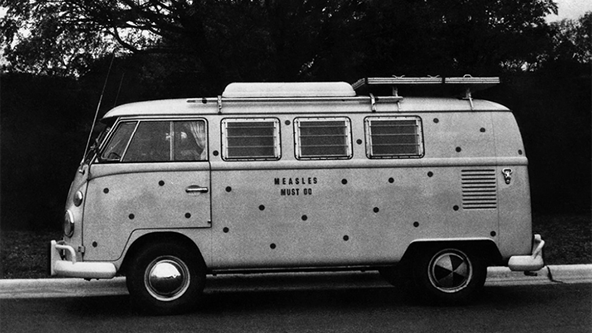 A spotted vaccine delivery vehicle displays the message, "MEASLES MUST GO", on its side.